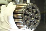 A CANDU fuel bundle, manufactured by BWXT, being held by a white glove.