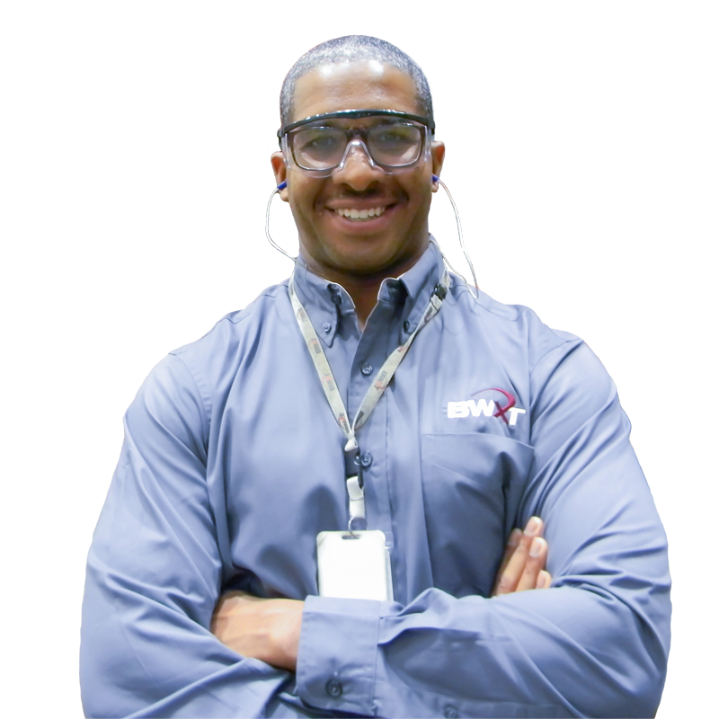 BWXT employee wearing safety glasses with arms crossed