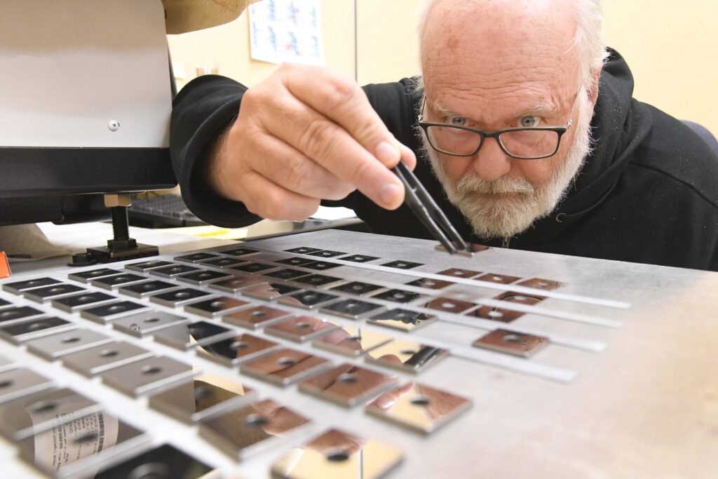 Nuclear operations employee focused on sorting complex parts.